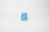 Small blue-tinted glass with a subtly irregular shape, set against a plain white background highlighting its translucent texture and smooth curves.