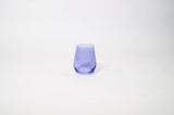 Veri Peri Purple Stemless Colored Wine Glass from glasshauseco, vivid purple hue, on a textured surface with soft light reflections