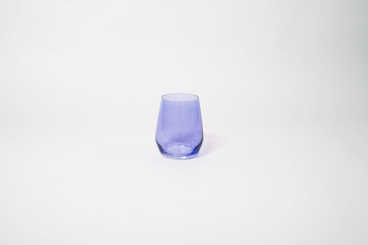 Veri Peri Purple Stemless Colored Wine Glass from glasshauseco, vivid purple hue, on a textured surface with soft light reflections