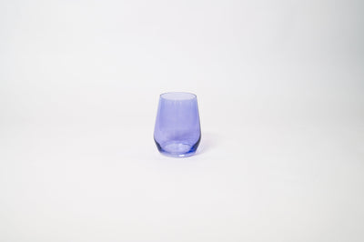 Veri Peri Purple Stemless Colored Wine Glass from glasshauseco, vivid purple hue, on a textured surface with soft light reflections