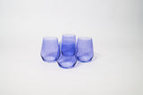 Set of four translucent purple wine glasses with rounded bases and tapered tops arranged on white background.