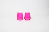 Two hot pink stemless wine glasses with a slightly faceted design, displayed side by side on a plain white background.