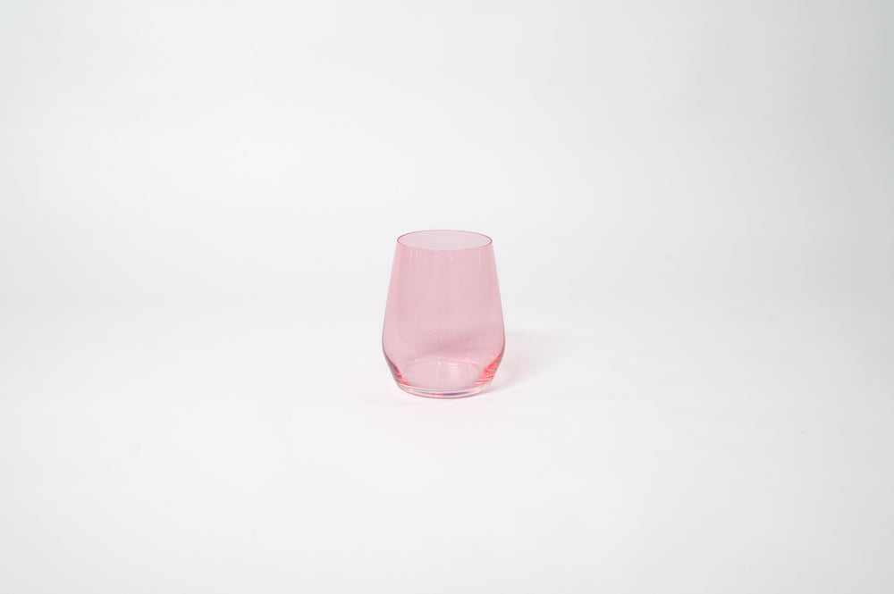 Bubblegum Pink - Stemless Colored Wine Glass by GlassHauseCo on a wooden table with warm, natural light