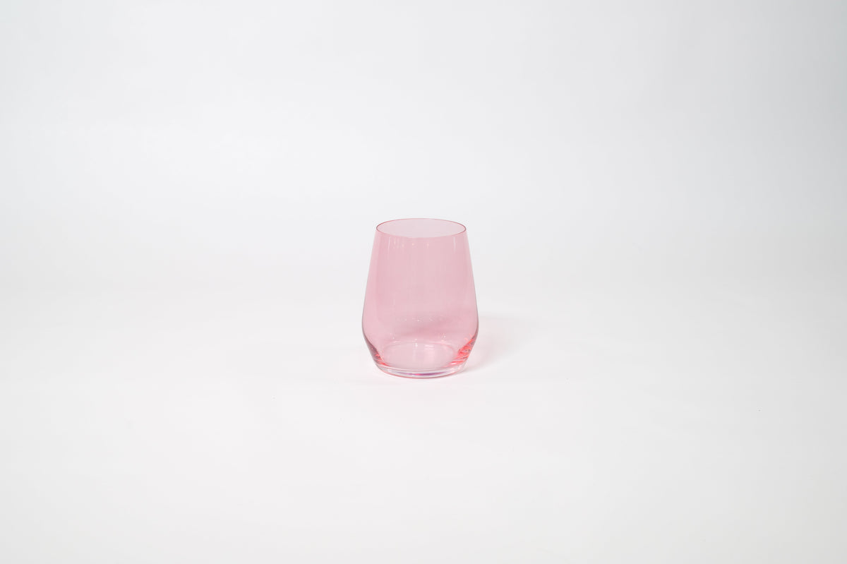 Bubblegum Pink - Stemless Colored Wine Glass by GlassHauseCo on a wooden table with warm, natural light