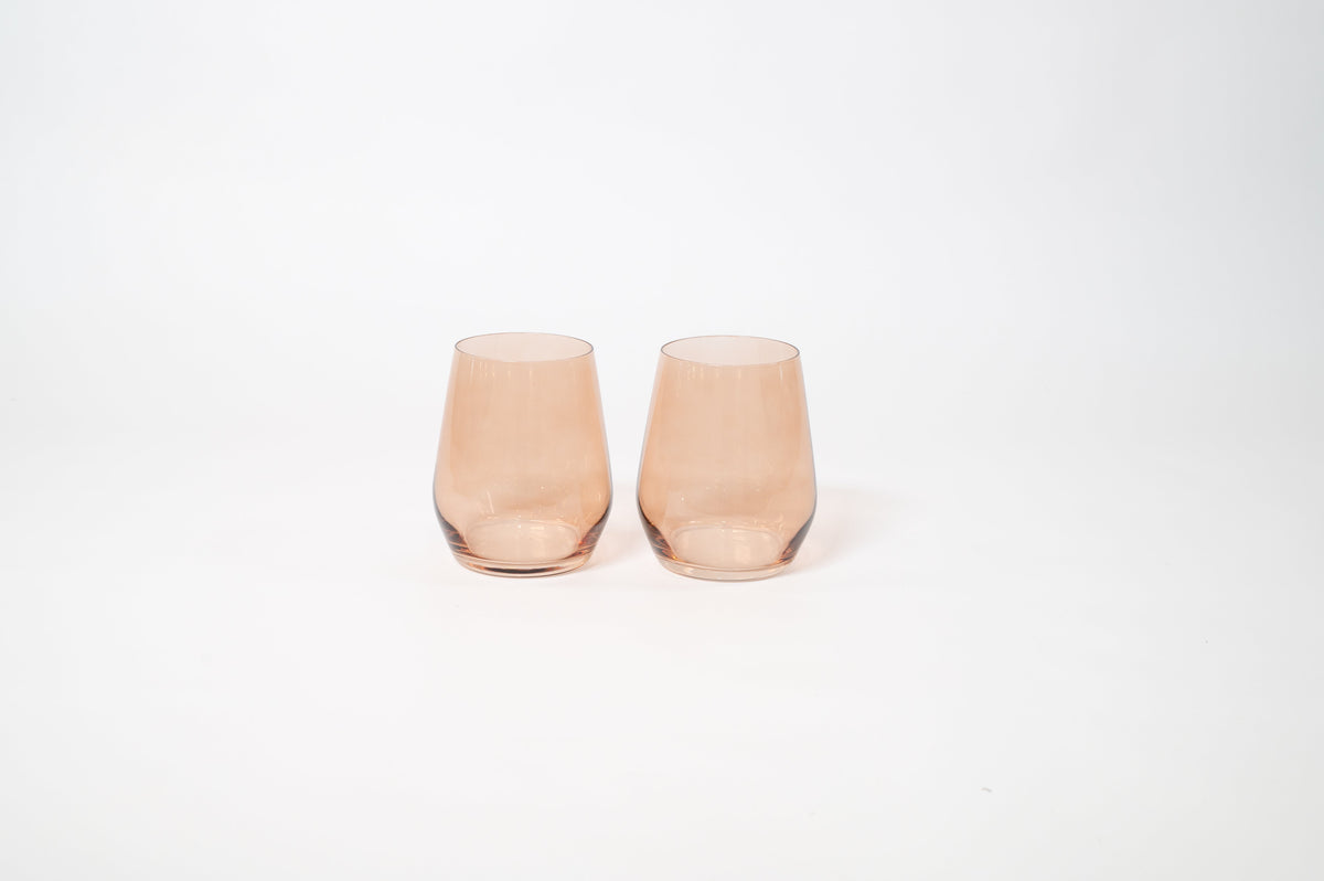 Two stemless brown-colored wine glasses with a smooth, slightly tapered shape set side by side on a white background.
