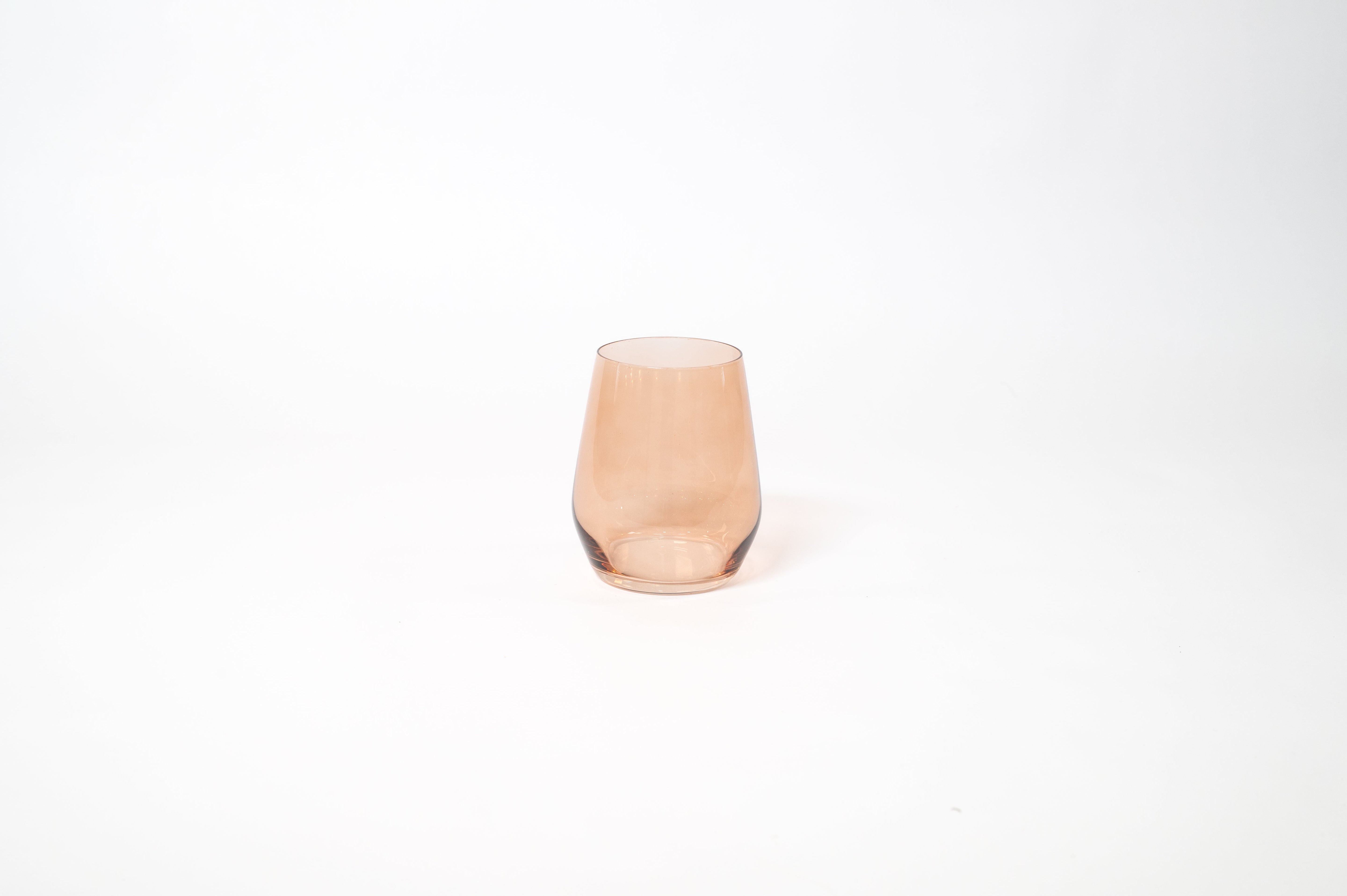 Brown Sugar Stemless Colored Wine Glass showing warm ombré hues on a wood table