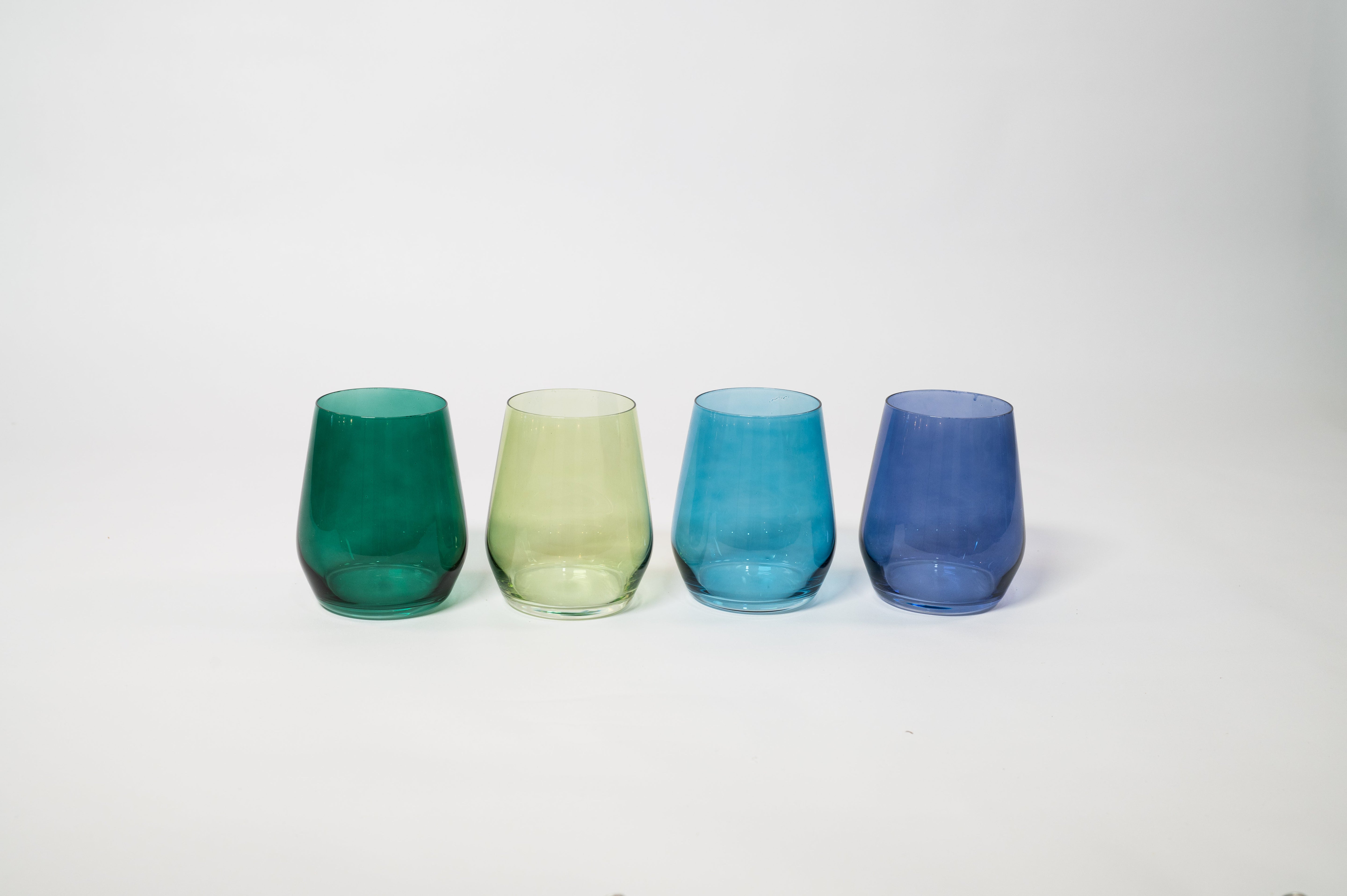 Four diverse colored stemless wine glasses from Northern Lights Collection arranged on a table