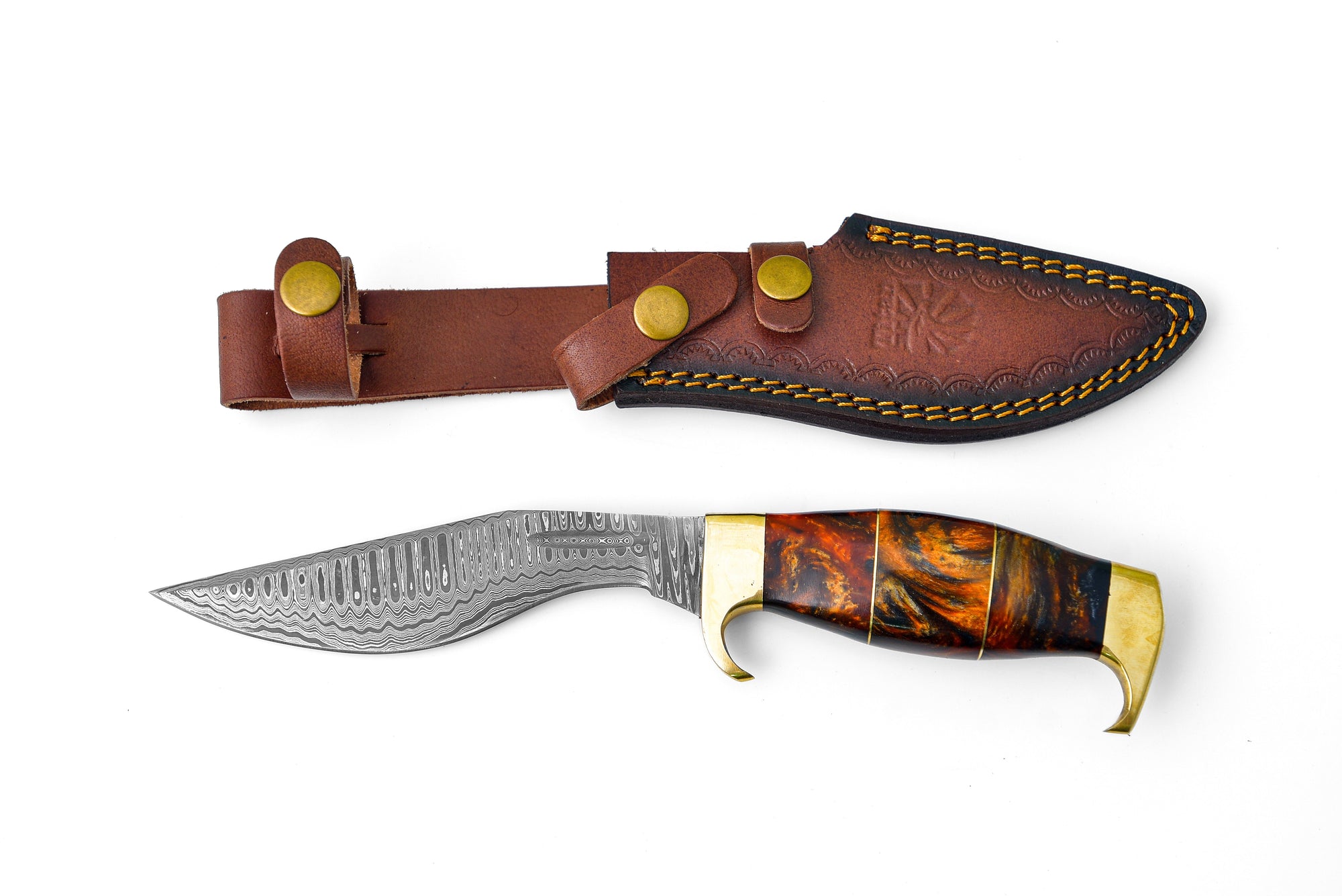 Damascus Steel 'Galaxy' Outdoor Chopping Tool with orange resin and brass handle resting on a wooden surface