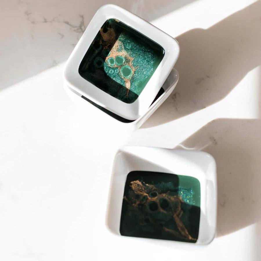 Square resin ceramic dish with green and brown marbled design on a white background