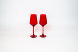 Two transparent cherry red stemmed wine glasses with a smooth, tapered shape against a plain white background.