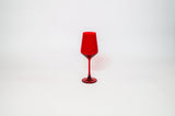 Bright cherry red stemless wine glass with a tapered bowl and slender stem, set against a plain white background.