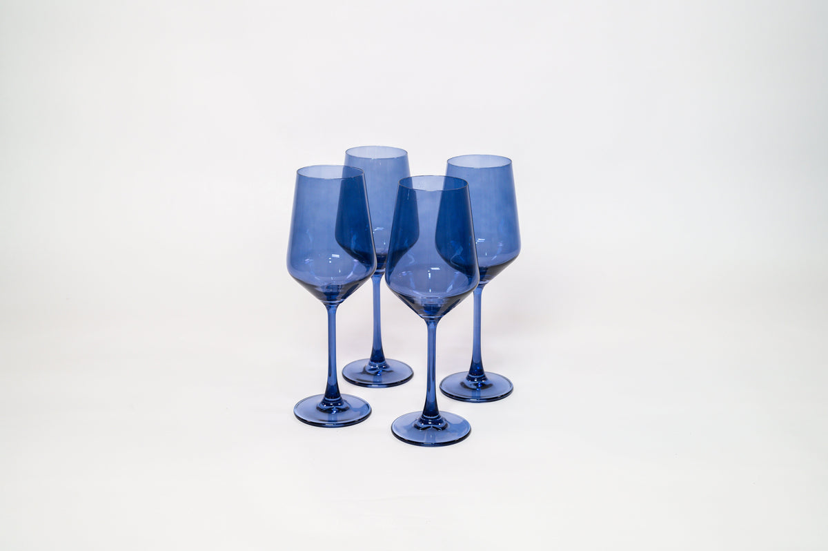 Set of four translucent blue wine glasses with a smooth finish, standing upright on a white surface against a plain white background.