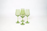 Four translucent matcha green stemless wine glasses with a slight gradient, arranged in a small cluster on a white background.