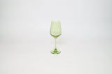 Transparent light green wine glass with a tall stem and gently flared bowl, standing centered on a plain white background.