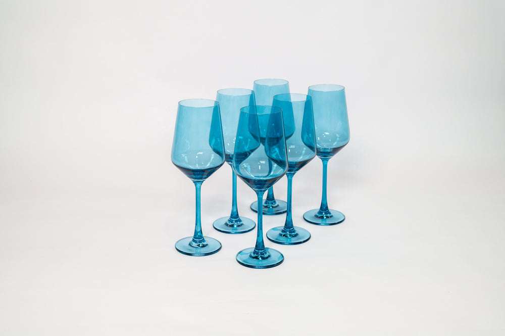 Blue Lagoon colored wine glasses on a wooden table with soft natural light