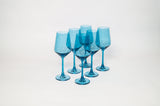 Blue Lagoon colored wine glasses on a wooden table with soft natural light