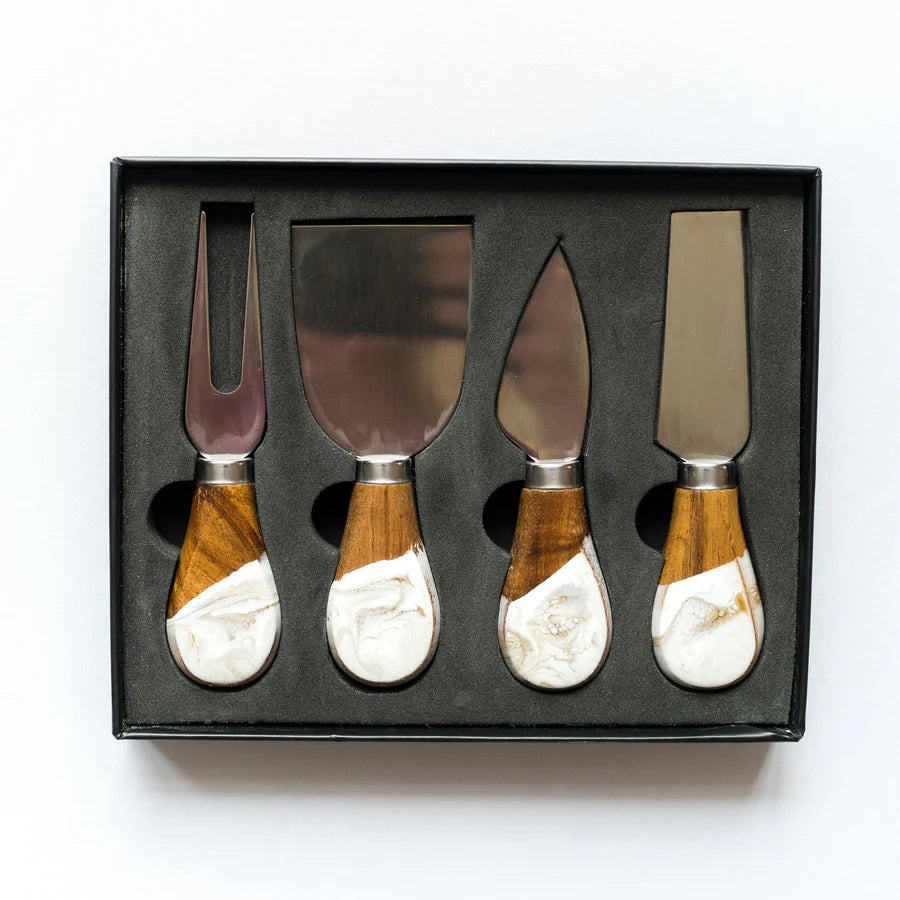 Set of four resin cheese knives with wooden handles in a black box on a white background