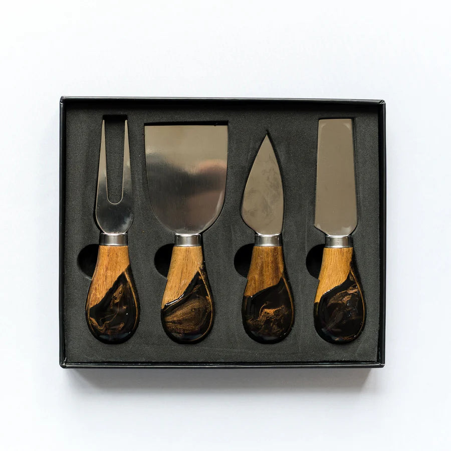 Set of four cheese knives with resin wooden handles in a black box on a white background