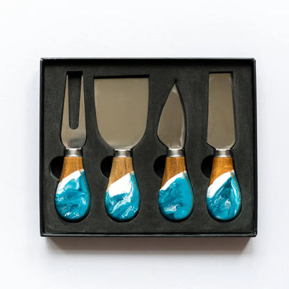 Set of four resin cheese knives with turquoise and wood handles in a black box on a white background