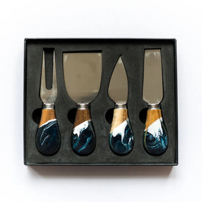 Set of four resin cheese knives with wooden handles in a black box on a white background