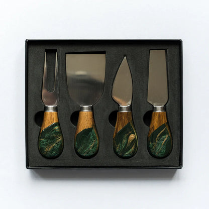 Set of four resin cheese knives with wooden handles in a black box on a white background