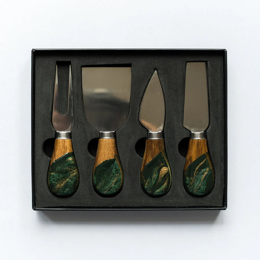 Set of four resin cheese knives with wooden handles in a black box on a white background
