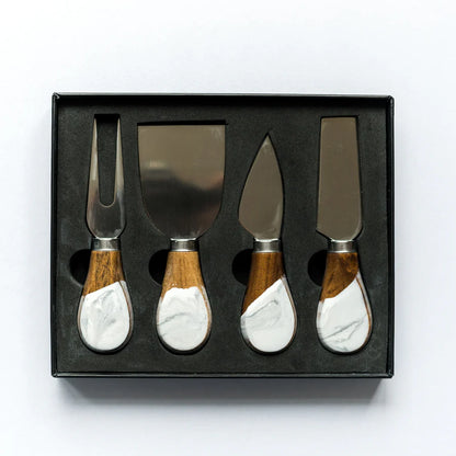 Set of four resin cheese knives with wooden and marble handles in a black box on a white background