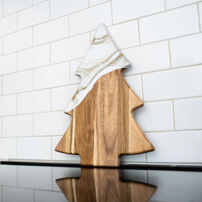 Christmas Tree shaped serving board made of acacia wood with green resin accent, styled with holiday snacks.