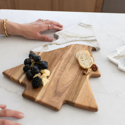Christmas Tree shaped serving board made of acacia wood with green resin accent, styled with holiday snacks.
