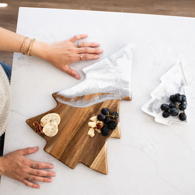 Christmas Tree shaped serving board made of acacia wood with green resin accent, styled with holiday snacks.