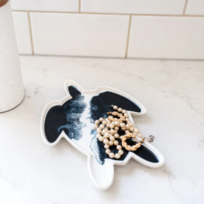 Decorative resin ceramic turtle plate with a necklace on a marble surface