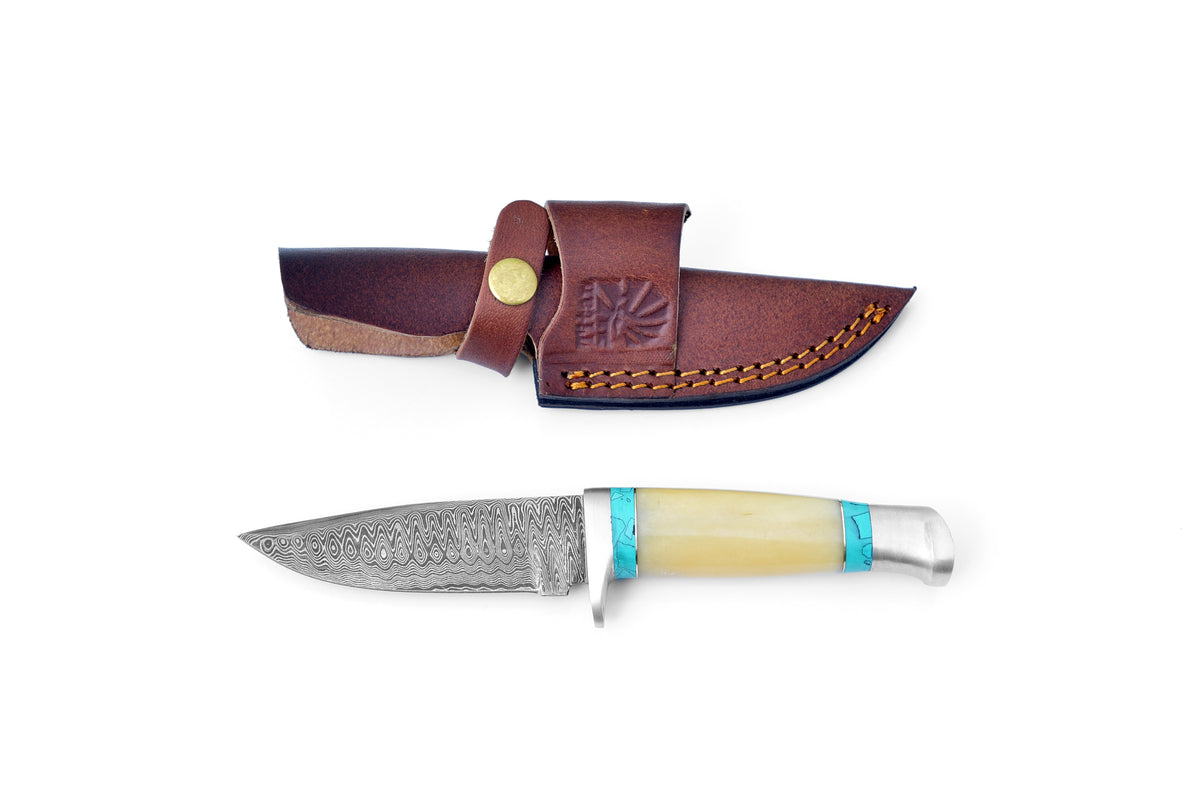 Titan International K Damascus Knife with a 4-inch blade and resin & bone handle resting on a wooden surface