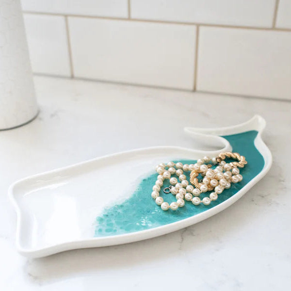Teal and white decorative resin tray with pearls on a marble surface