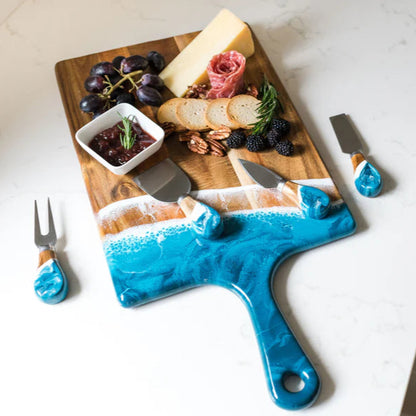 Blue resin cheese board with a knife and charcuterie on a white surface