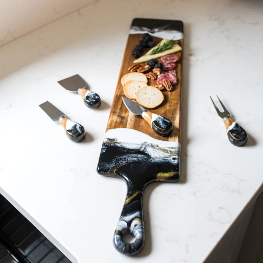 Wooden resin charcuterie board with sliced meats and cheeses on a marble surface