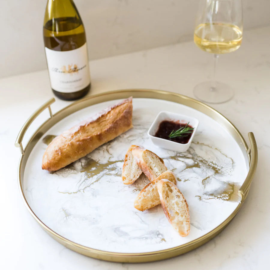 Tray with bread, a bottle of wine, and a glass on a resin marble surface of a tray