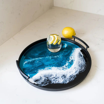 Decorative resin tray with blue ocean wave design on a white surface