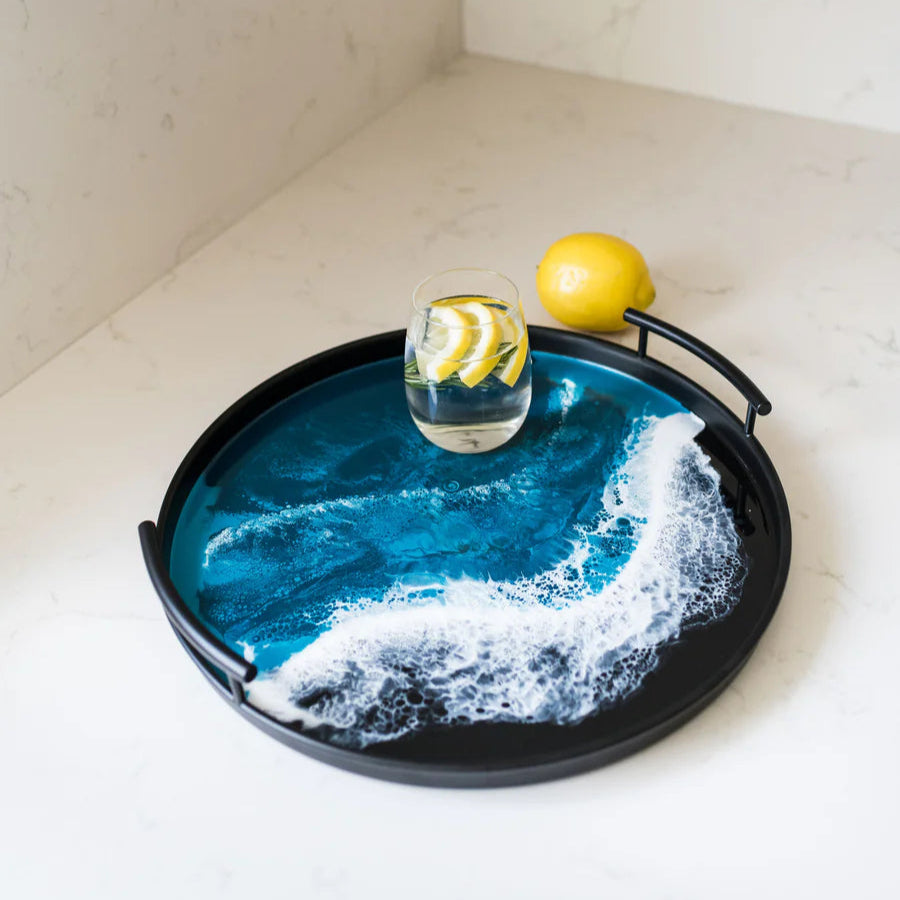 Decorative resin tray with blue ocean wave design on a white surface