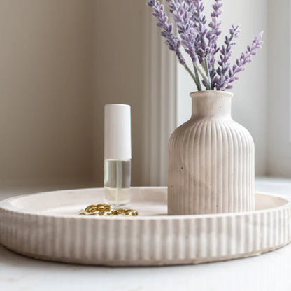Decorative vase with lavender on a tray by a window