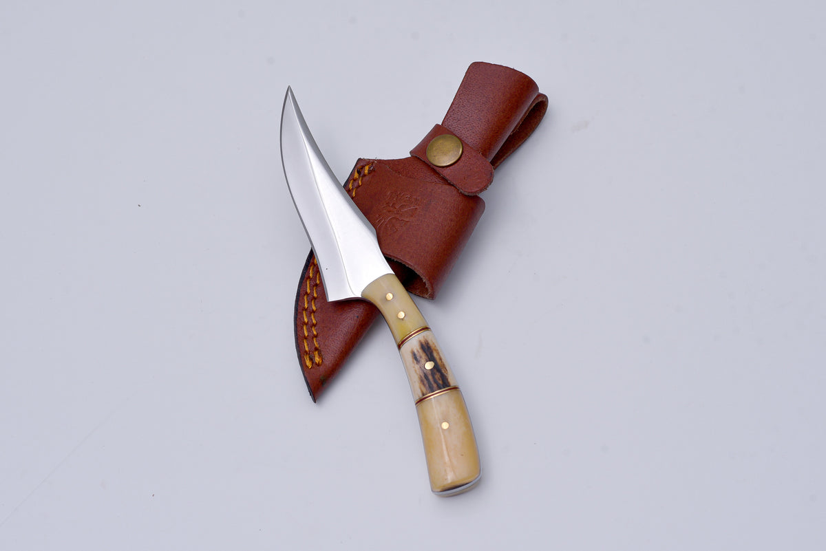 Titan Wayfarer Utility and Hunting Knife with bone and stag handle resting on a dark surface