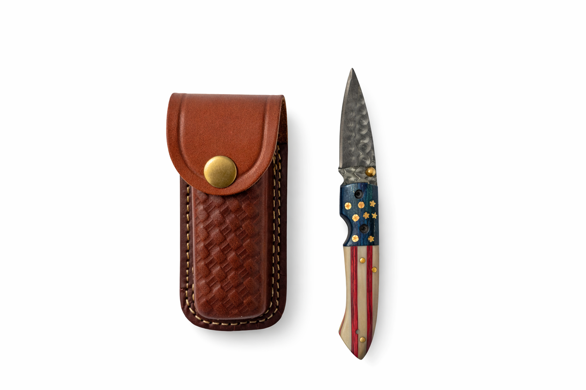 Titan Patriot Damascus Folding Knife with leather sheath showing folded handle with layered red, white, and blue design and brass details