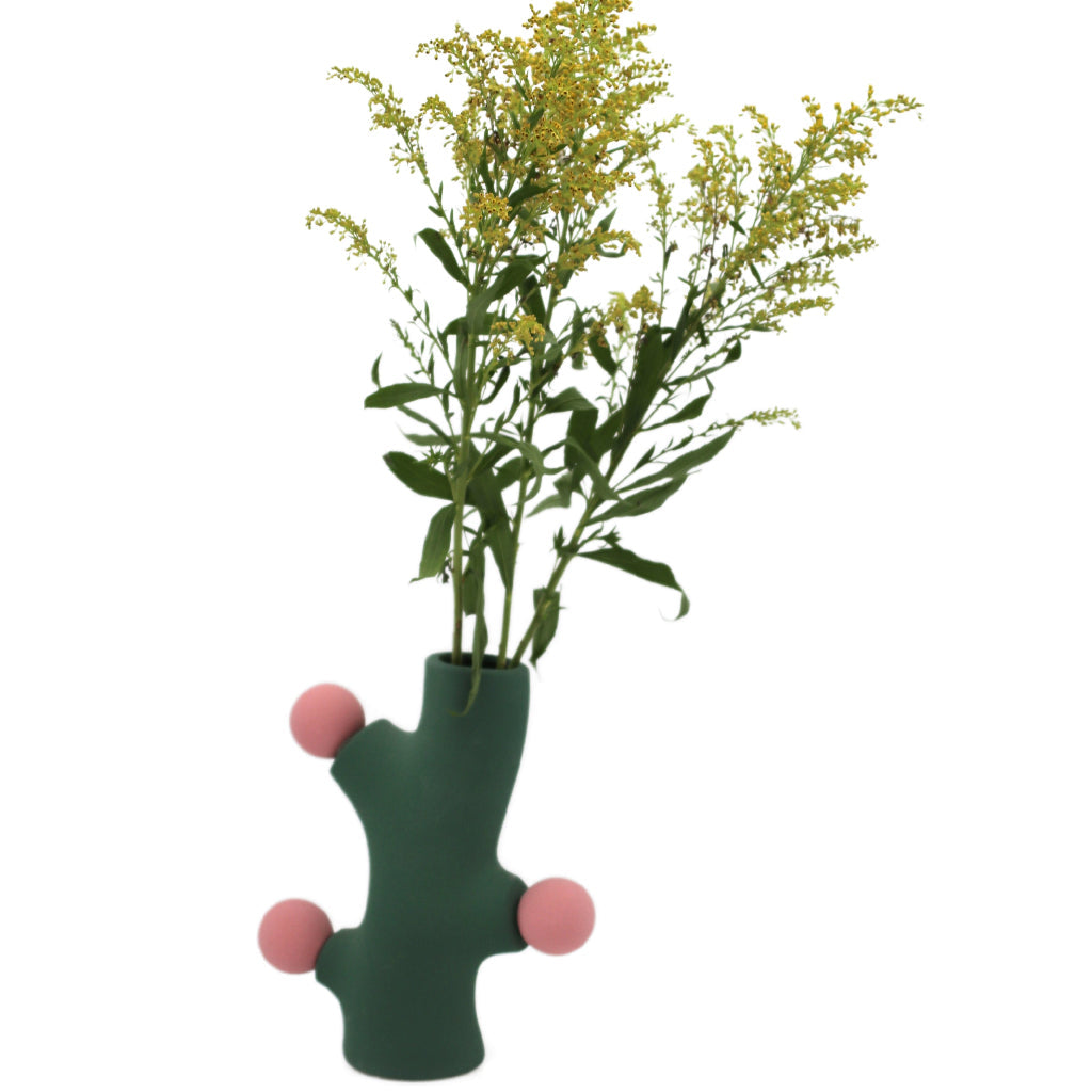 Deco Cacti Vase in sage green matte ceramic with pink protrusions shown on a table in neutral interior setting