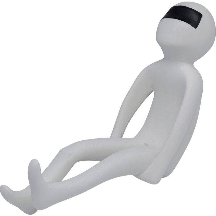 Minimalist white figurine with a smooth surface sitting with legs extended and arms relaxed, featuring a black band covering its eyes.