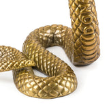 Close-up of a gold-colored snake sculpture with textured scales and 'DON' lettering on the raised head section, coiled on a white background.