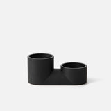 Matte black double planter with two cylindrical pots of different heights connected by a flat rectangular base, shown against a white background.