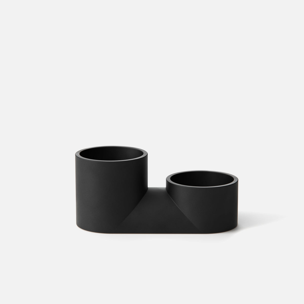 Matte black double planter with two cylindrical pots of different heights connected by a flat rectangular base, shown against a white background.