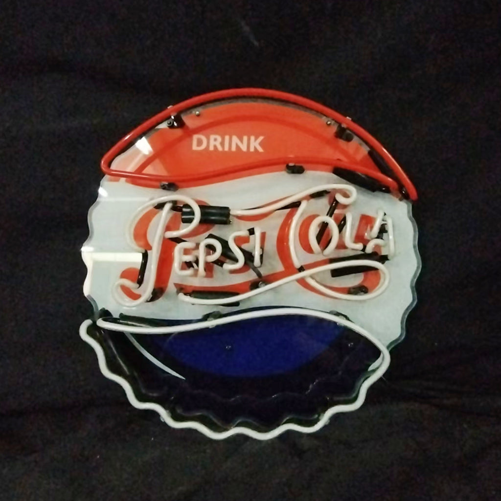 Round Pepsi-Cola neon sign shaped like a bottle cap with red, white, and blue sections and scripted 'Pepsi-Cola' lettering on a black background.