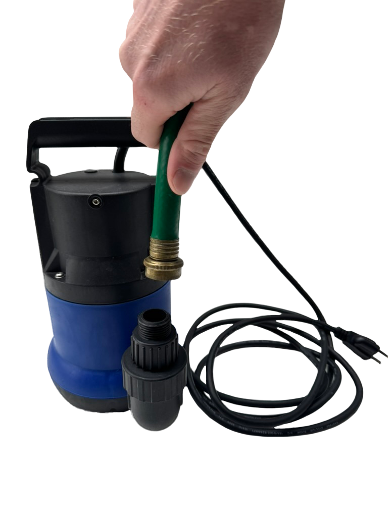 Black and blue submersible pump connected to a green hose held by a hand, with a coiled black power cord beside it on a white surface.