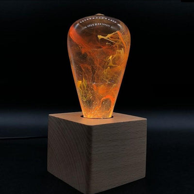 Three handcrafted resin LED light bulbs in a bundle, showing unique color patterns and resin designs