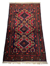 Rectangular hand-knotted Afghani Baluch wool rug featuring three central red diamond motifs with surrounding geometric patterns in red, black, and beige, accented by cream fringes.